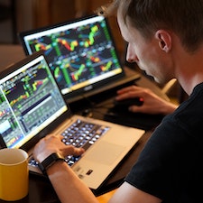 Man looking at a stock chart displayed on his computer
